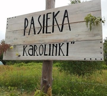 fot. facebook Dynioland.edu.pl, www.facebook.com/dynioland. Na zdjęciu drewniana tablica z napisem PASIEKA "KAROLINKI"