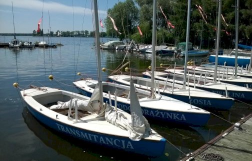 fot. www.wojsko-polskie.pl/wat/osrodek-szkoleniowy-w-zegrzu. Na zdjęciu łodzie na wodzie przy pomoście, z tyłu drzewa