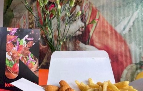 fot. facebook Kebabownia, www.facebook.com/Kebabownia-724699637887448. Na zdjęciu w pudełku kawałki kurczaka z frytkami, karta menu, tapeta chłopca na ścianie