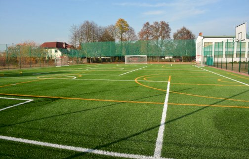 fot. https://www.nieporet.pl/spolecznosc-gminna/boisko-wielofunkcyjne-przy-zespole-szkolno-przedszkolnym-w-wolce-radzyminskiej/. Na zdjęciu boisko wielofunkcyjne do gry w piłkę nożną, ręczną, koszykową