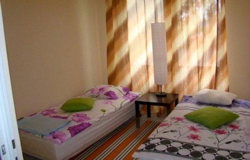 Powiększ obraz: fot. facebook Przystań Przy Starym Moście. Pokój dla gości z 2 łóżkami, lampka na stoliku między łóżkami