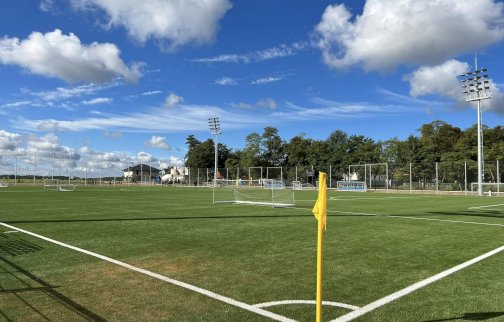 fot. facebook Urząd Miasta Gminy Serock. Na zdjęciu boisko do piłki nożnej, wysokie maszty ledowe na boisku, bramki do gry, w oddali ławki sędziowskie