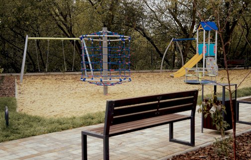 fot. Urząd Miasta i Gminy Serock, https://serock.pl/1855-serock-plac-zabaw-w-izbicy. Na zdjęciu huśtawki, linarium, mały domek w zestawie zjeżdżalnia, mała ścianka wspinaczkowa, zjeżdżalnia, karuzela, ławka do siedzenia na chodniku