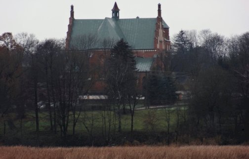 Powiększ obraz: Na zdjęciu kościół w Dzierżeninie widziany po drugiej stronie rzeki Narew za wałem ziemnym w Łasze