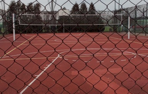 fot. Krzysztof Kozań. Na zdjęciu boisko do piłki koszykowej oraz siatkowej, ustawiona siatka do gry pośrodku boiska