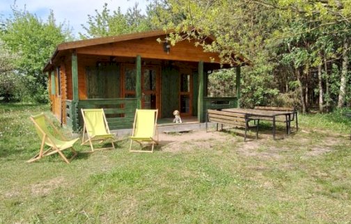 fot. www.rybaczowka.com.pl/noclegi. Na zdjęciu Rybaczówka Dom Pracy Twórczej, leżaki, stół z ławkami do siedzenia