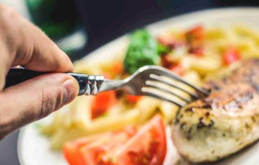 fot. facebook Aldar Catering, https://www.facebook.com/p/Aldar-Catering-100070899792850/. Na zdjęciu danie obiadowe, osoba z widelcem sięga po jedzenie