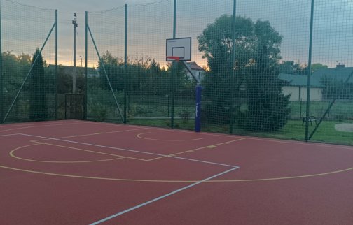 fot. www.nieporet.pl/pliki/przebudowa-boiska-w-ryni-gm-nieporet/. Na zdjęciu boisko o nawierzchni sztucznej do gry w piłkę koszykową