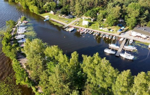 fot. Kompleks Rekreacyjno-Wypoczynkowy Nieporęt - Pilawa, foto nr 34, M.Pater. Na zdjęciu przystań dla łodzi motorowych, żeglarskich, w tle drzewa, zabudowania