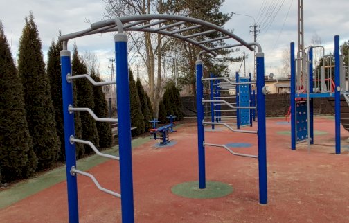 fot. Krzysztof Kozań. Na zdjęciu drabinki, huśtawka sprężynowa, małe linarium, ścianki wspinaczkowe, z tyłu fragment zabudowań mieszkalnych