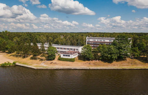 fot. www.rewita.pl/obiekt/rewita-rynia-galeria/. Na zdjęciu Ośrodek Rewita Rynia, plaża, w tle drzewa