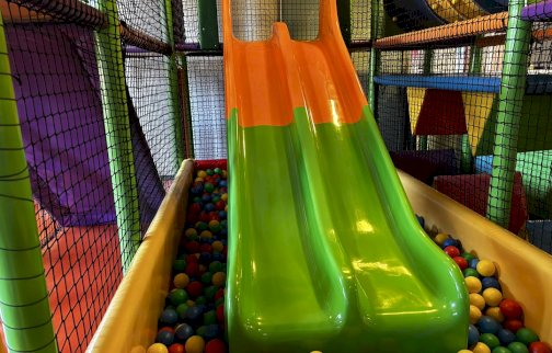 fot. facebook Hop - Cafe Bawialnia i klubokawiarnia, https://www.facebook.com/hopcafelegionowo. Na zdjęciu zjeżdżalnie dla dzieci, plastikowe kulki w basenie dla dzieci