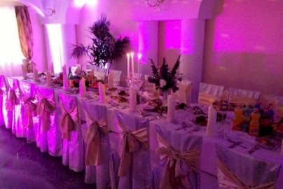 Powiększ obraz: fot. www.domweselnylanda.pl/. Na zdjęcie sala weselna Domu Weselnego Landa,  biały obrus, jedzenie, napoje na stole