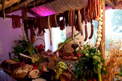 Powiększ obraz: fot. www.domweselnylanda.pl/. Na zdjęciu wędzone wędliny, kiełbasy wiszące na elemencie drewnianym zabudowy