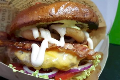 Powiększ obraz: fot. facebook Bistro u Miśków, https://www.facebook.com/profile.php?id=100063485915346. Na zdjęciu burger z bekonem, serem żółtym i sosem