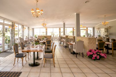 Powiększ obraz: fot. restauracjaoranzeria.com/. Na zdjęciu restauracja, stoliki z krzesełkami, kwiaty