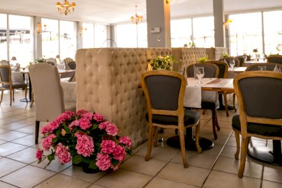 Powiększ obraz: fot. restauracjaoranzeria.com/. Na zdjęciu restauracja, stoliki z krzesełkami, kwiaty