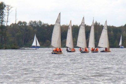 Powiększ obraz: fot. https://wiatr.waw.pl/#site-footer. Na zdjęciu osoby w kamizelkach pływają łodziami żaglowymi na wodzie