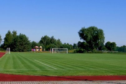 Powiększ obraz: fot. sis.serock.pl/3926,boisko. Na zdjęciu boisko o nawierzchni trawiastej do piłki nożnej, bieżnia ze sztucznej nawierzchni, położona bramka po lewej stronie, oraz dwie pozostałe stojące bramki