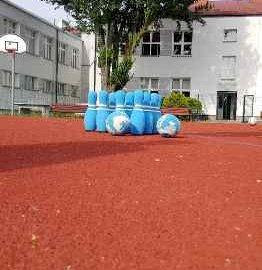 Powiększ obraz: fot. www.jablonna.pl/kultura-i-sport/zawartosc/383/. Na zdjęciu boisko do gry, w tle Szkoła Podstawowa  nr 2  im. Orła Białego w Chotomowie