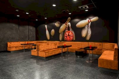 Powiększ obraz: fot. www.warszawianka.pl/pl/. Na zdjęciu narożne sofy do siedzenia, stoliki, tapeta na ścianie w kształcie kręgli