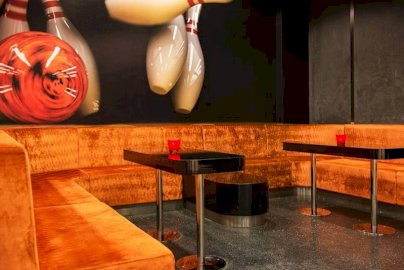 Powiększ obraz: fot. www.warszawianka.pl/pl/. Na zdjęciu narożna sofa, stoliki, tapeta na ścianie w kształcie kręgli