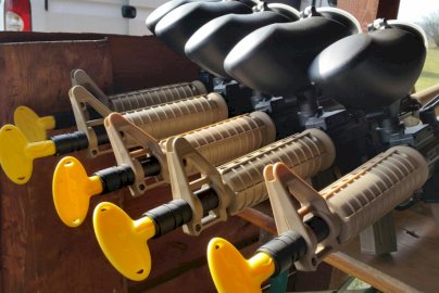 Powiększ obraz: fot. www.eventimpression.pl/paintball. Na zdjęciu broń przeznaczona do gry w paintballa, w tle fragment maski samochodu