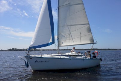 Powiększ obraz: fot. www.sailingschool.pl/. Na zdjęciu łódź żaglowa, w środku na pokładzie osoby