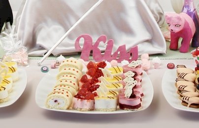 Powiększ obraz: fot. www.sweet-home.pl. Na zdjęciu na białych półmiskach ciastka, ciasta, babeczki, figurki kotów, napis Kiss