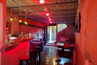 Powiększ obraz: fot.  facebook Pub "Na dołku", www.facebook.com/NaDolkuPub/, Na zdjęciu widok na bar z krzesłami, stoliki z krzesełkami, zegar po lewej stronie na ścianie