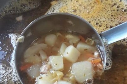 Powiększ obraz: fot. facebook Ra BAR bar, www.facebook.com/cisrabarbar/. Na zdjęciu zupa z ziemniakami i marchewką.  Łyżka wazowa w zupie