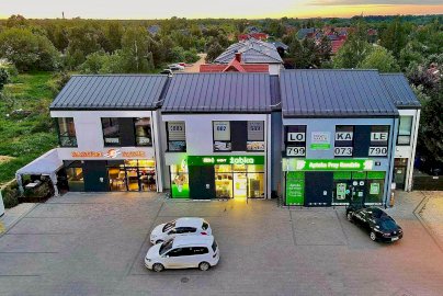 Powiększ obraz: fot. sasorisushi.pl. Na zdjęciu lokal Sasori Sushi  z zewnątrz, obok sklep Żabka, samochody stojące na parkingu na zewnątrz