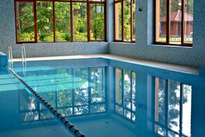 Powiększ obraz: fot. Hotel Pan Tadeusz. Na zdjęciu basen, lina przedziela tor w basenie, okna wychodzą na otoczenie Hotelu Pan Tadeusz w Serocku