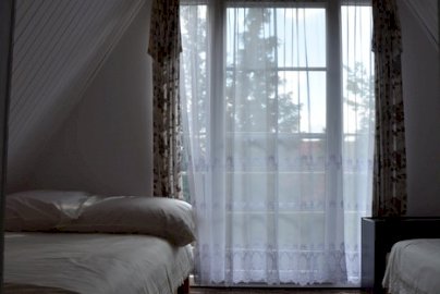 Powiększ obraz: fot. www.nocleginadzalewem.pl/index.php. Na zdjęciu dwa pojedyncze łóżka przy oknie