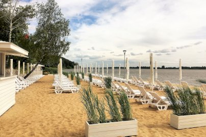 Powiększ obraz: fot. www.warszawianka.pl. Na zdjęciu plaża, ustawione w rzędach leżaki, widok na jezioro zegrzyńskie