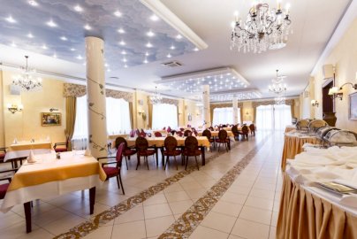 Powiększ obraz: Fot. www.hotelpantadeusz.pl. Na zdjęciu duża sala ze stolikami i krzesełkami, żyrandole, kolumny podtrzymujące strop