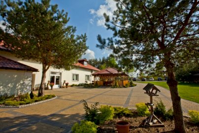 Powiększ obraz: fot. www.salagrand.pl. Na zdjęciu sala bankietowa GR-AND z zewnątrz, parking dla samochodów, karmik dla ptaków