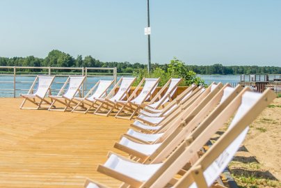 Powiększ obraz: fot. windsorhotel.pl. Na zdjęciu rozstawione leżaki do opalania stojące na pomoście,  fragment plaży