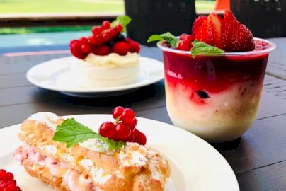 Powiększ obraz: fot. www.facebook.com/Tawerna-Portowa-1577325402530886/photos/?ref=page_internal. Na zdjęciu bułka z kremem, maliny na talerzyku, mus owocowy