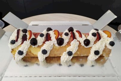 Powiększ obraz: fot. facebook Cukiernia Midas Jachranka, www.facebook.com/Cukiernia-Midas-Jachranka-108897208054026/photos/?ref=page_internal. Na zdjęciu rolada z bitą śmietaną, borówkami, brzoskwiniami