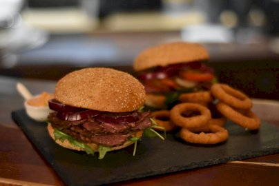 Powiększ obraz: fot. www.beef-burger.pl. Na zdjęciu burgery, krążki cebulowe