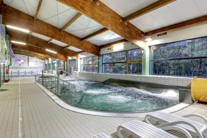 Powiększ obraz: fot. www.cr.nieporet.pl. Na zdjęciu niecka rekreacyjna z dyszami, które dostarczają wodę, z przodu leżaki, z boku przy ścianie ławki