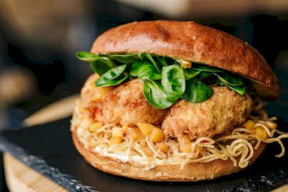 Powiększ obraz: fot. www.trustburger.pl/galeria. Na zdjęciu burger z kurczakiem i sałatą