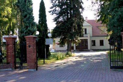 Powiększ obraz: fot. www.integracjaserock.pl/o-nas. Na zdjęciu front Integracyjne Centrum Opieki Wychowania Terapii w Serocku, brama wjazdowa