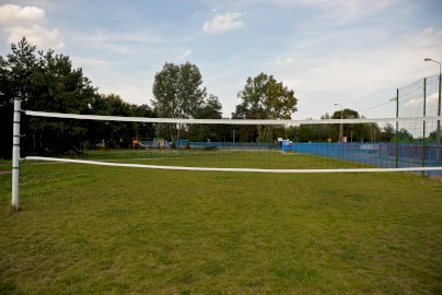 Powiększ obraz: fot. https://www.osirjablonna.pl/baza-sportowa/boisko-w-suchocinie#gallery-2. Na zdjęciu boisko do gry w piłkę siatkową o naturalnej nawierzchni