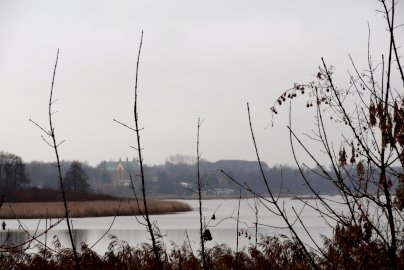 Powiększ obraz: Na zdjęciu kościół w Dzierżeninie widziany po drugiej stronie rzeki Narew za wałem ziemnym w Łasze