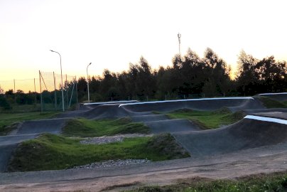Powiększ obraz: Na zdjęciu widok pumptracku w Skubiance z latarniami i boiskiem w tle