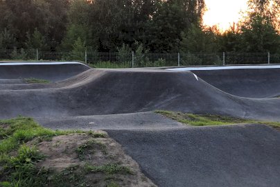 Powiększ obraz: Na zdjęciu ujęcie pumptracku w Skubiance o zmierzchu, z widocznymi zakrętami i drzewami w tle