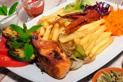 Powiększ obraz: fot. facebook Urfa Kebab Legionowo, https://www.facebook.com/urfa.kebab2021/. Na zdjęciu pieczony łosoś z frytkami i startą marchewką, sosy do dania
