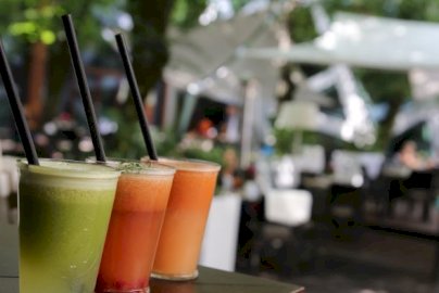 Powiększ obraz: fot. www.hotelnarvil.pl. Na zdjęciu koktajle w wysokich szklankach ze słomkami, z tyłu stoliki z krzesełkami do siedzenia